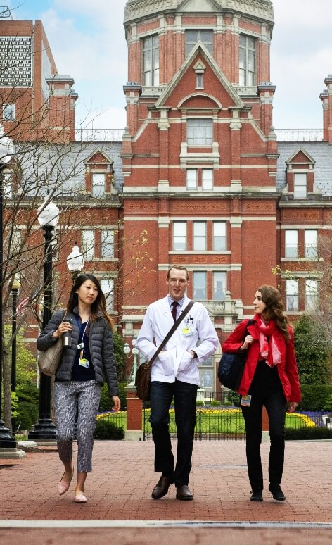 Three students walk away from a campus building.